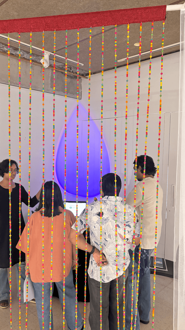 Visitors gathered at the booth, seen through the beaded curtain at its entrance