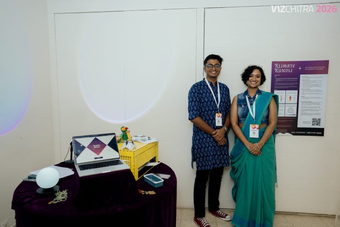 The two of us standing beside the Klimate Kundli booth and its poster