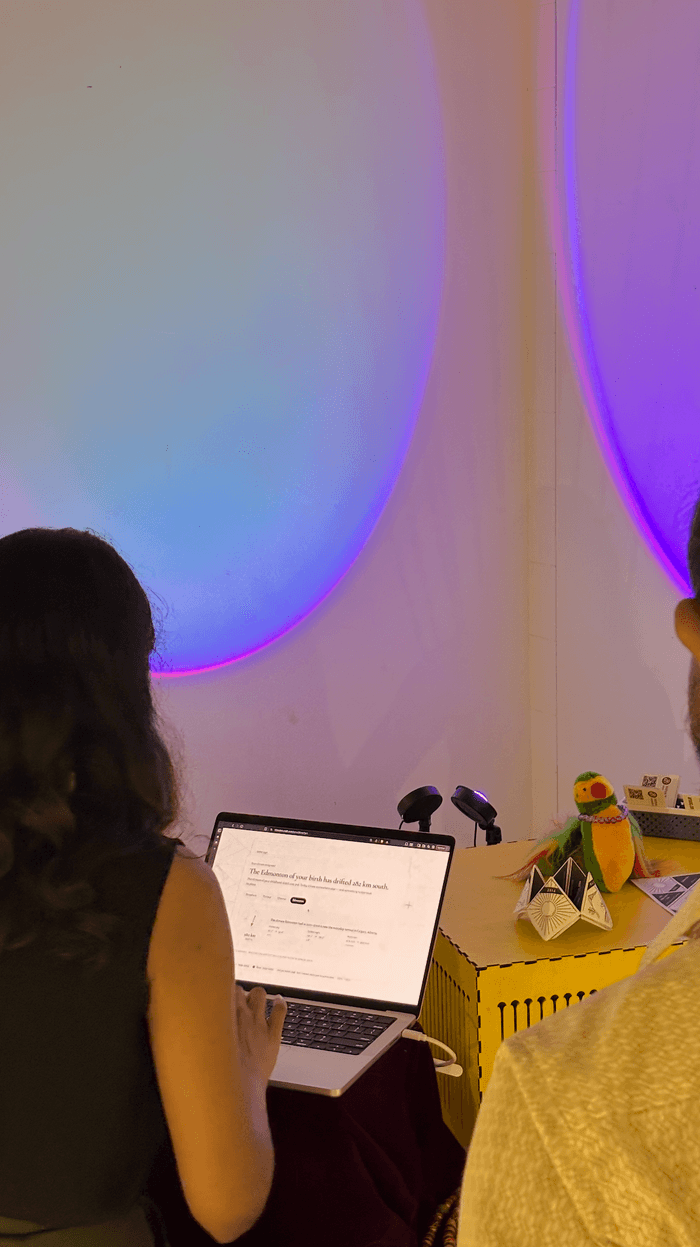 A visitor entering their details at the exhibit laptop, lit by the purple wall