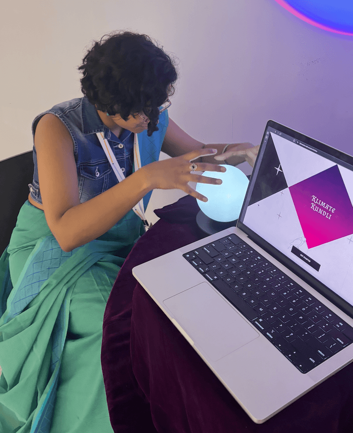 Working at the exhibit laptop, holding the glowing orb