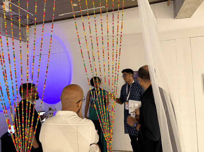 Visitors at the booth, framed by the beaded curtain