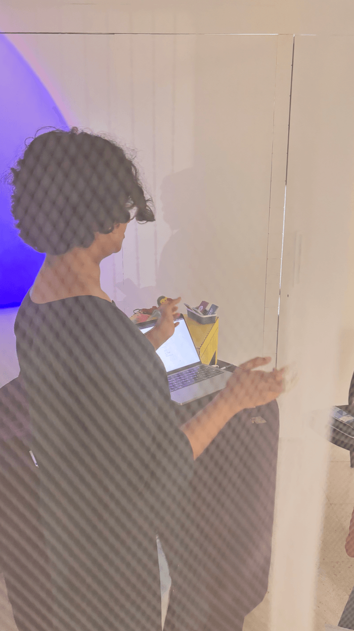 A visitor reading their printed kundli behind the frosted panel